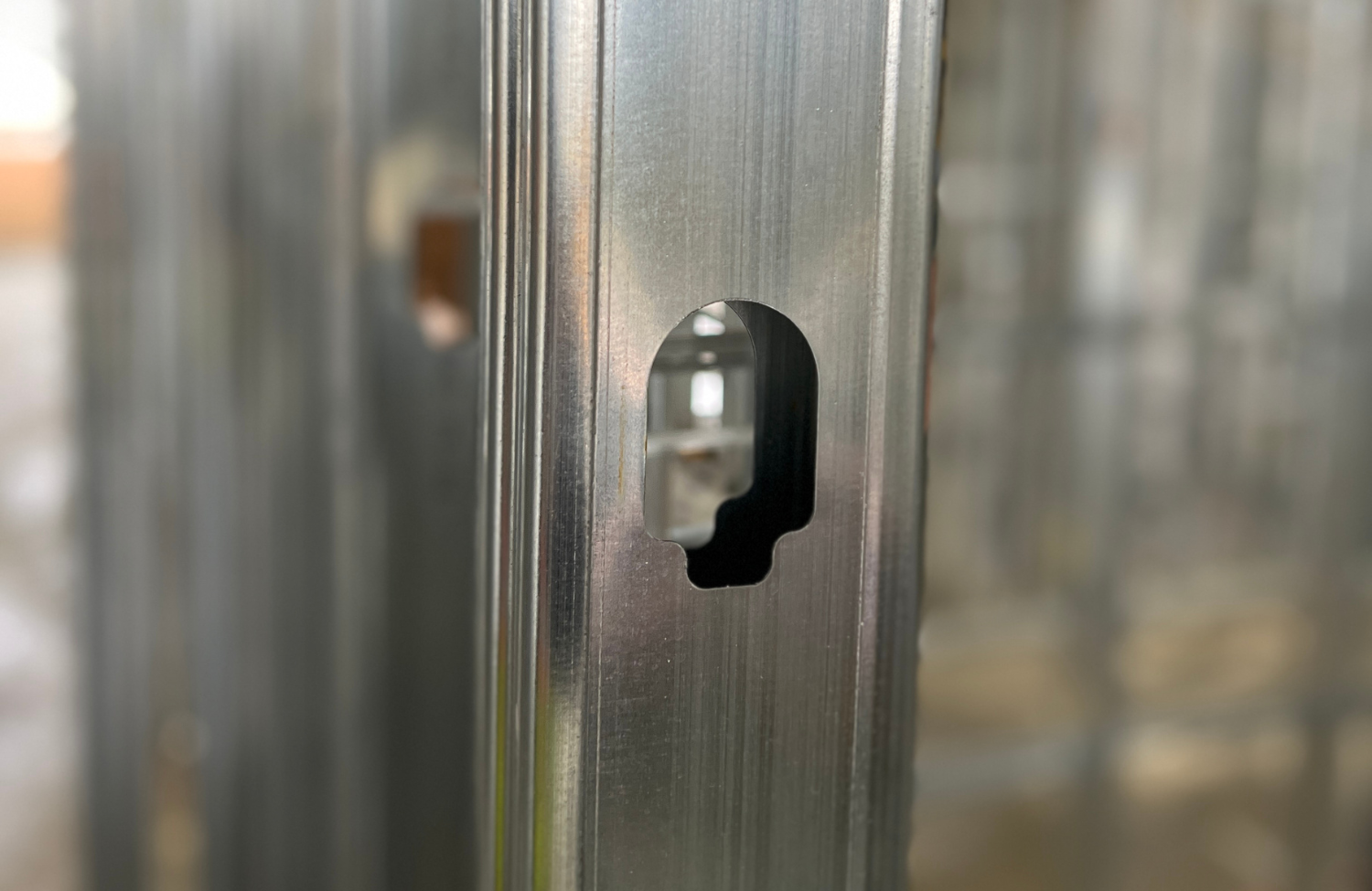 Enlarged knockout in ViperStud® drywall framing stud, designed for efficient routing of electrical and plumbing components